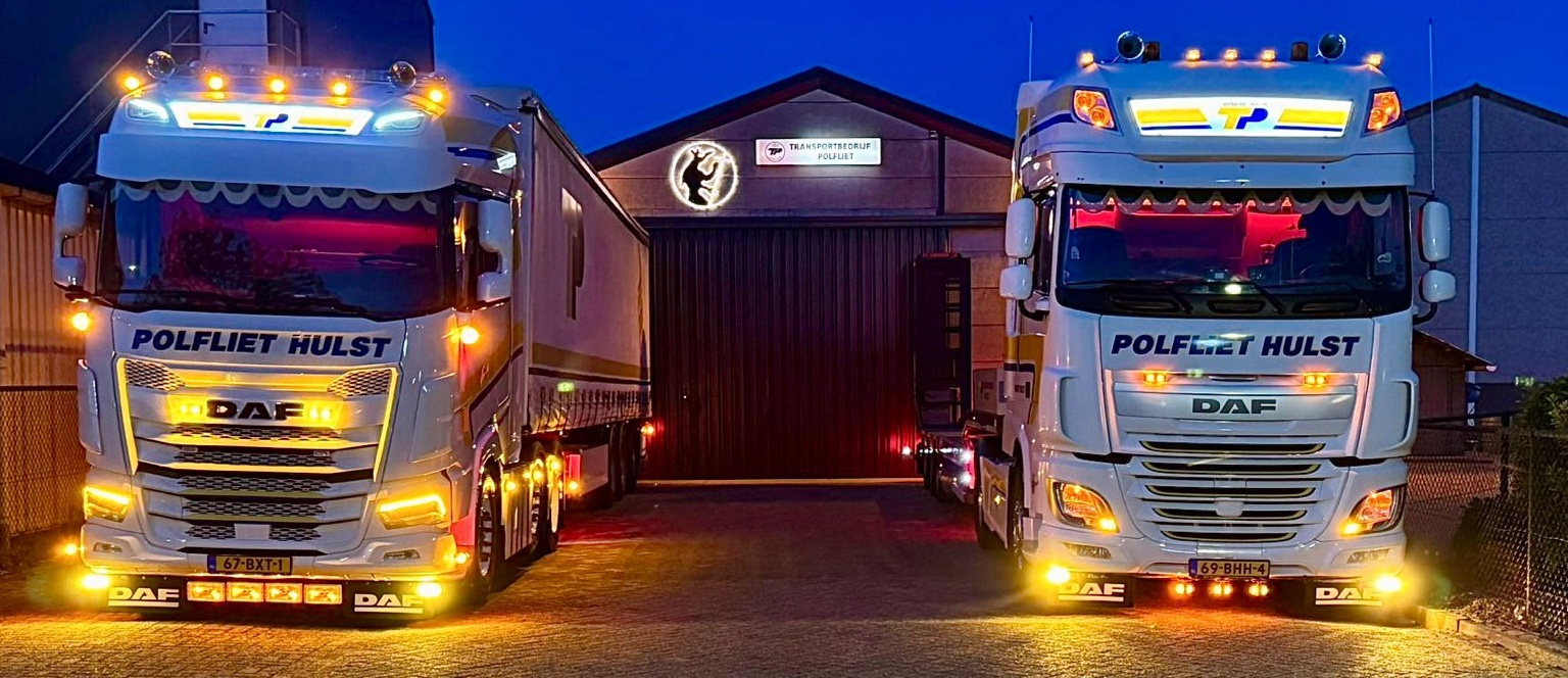 Vrachtwagens van Transport Polfliet bij het pand